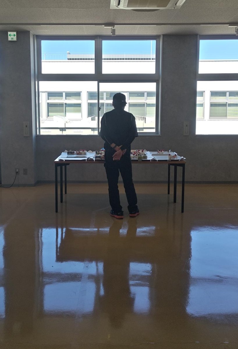 ケーキの前で悩む社員の後ろ姿